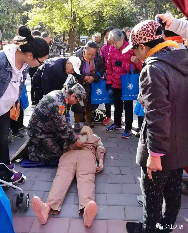 上图:在宣传活动主会场送变电社区,人防志愿者为社区百姓演示心肺复苏要领和方法。