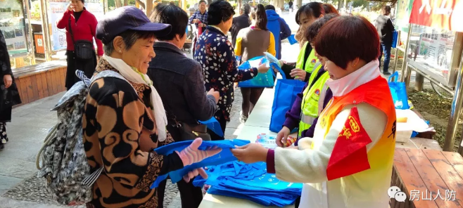 上图:在分会场伟业嘉园社区,人防社区工作者为社区百姓发放人防宣传册和人防宣传品。
